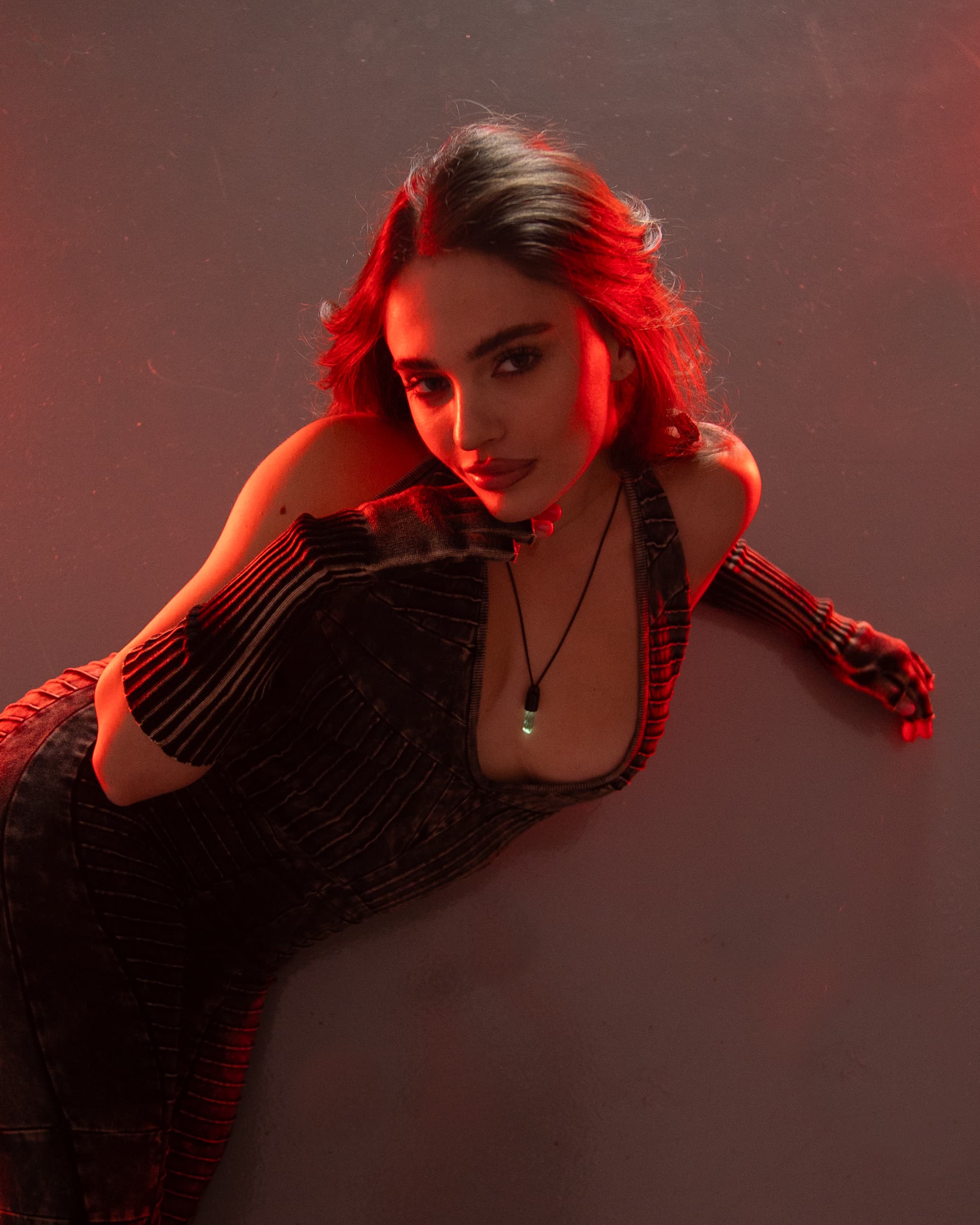 The Spire Pendant glowing in red studio light